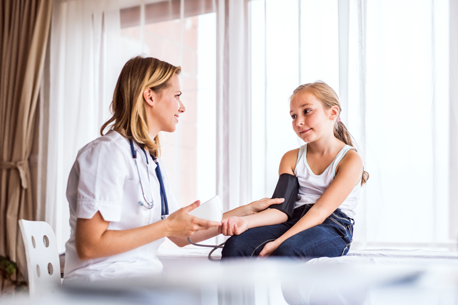 Young female doctor checking a small girl