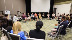 An indoor image of Amber King-Robitaille of Beausoleil First Nation speaking, while participants gather with her in a circle of trust.
