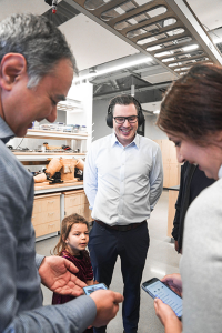 Minister Beech is testing out the headphone device, equipped with AI-based software.