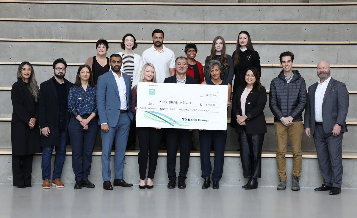 Minister Beech's daughter Nova and KBHN Interim CEO Geoff Pradella look over the Dino Island game on a tablet.